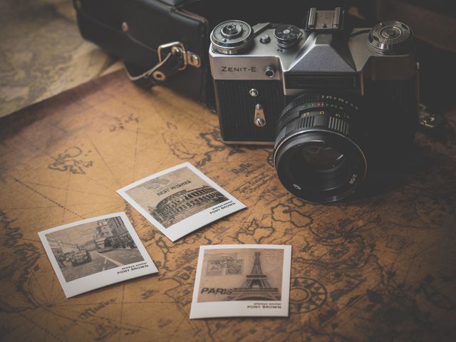 Showing an old-fashioned camera beside printed travel photographs on an antique world map, capturing nostalgia and wanderlust. Ideal for representing travel experiences, preserving old-world charm, or highlighting the art of classic photography and exploration.