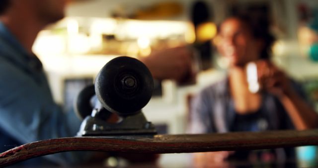 Close-up of Skateboard Wheel with Blurry People Enjoying Coffee in Background - Download Free Stock Images Pikwizard.com