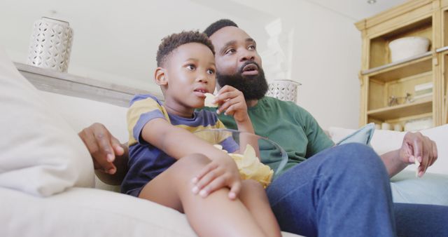 Father and son bonding at home while watching TV together on a cozy couch - Download Free Stock Images Pikwizard.com