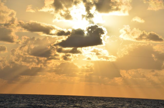 Sunset Over Ocean with Golden Clouds and Sunbeams - Download Free Stock Photos Pikwizard.com