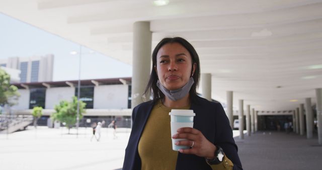 Confident Businesswoman Holding Coffee Cup in Modern Urban Area - Download Free Stock Images Pikwizard.com