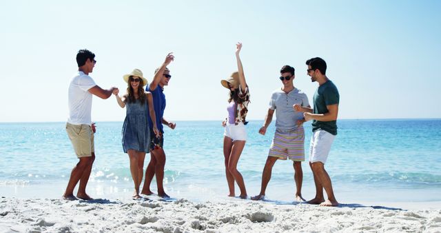 Young Adults Enjoying Lively Beach Day with Blue Ocean Background - Download Free Stock Images Pikwizard.com