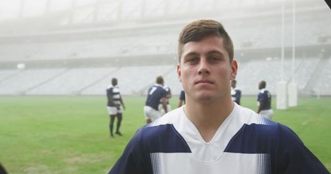 Rugby Player's Determined Portrait with Team in Stadium