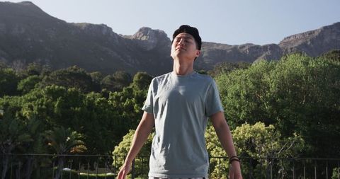 Young man embracing nature and finding tranquility in mountain landscape