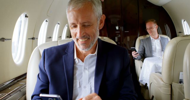 Caucasian businessmen travel in luxury, with copy space. They are working while commuting in a private jet, showcasing a mobile lifestyle.