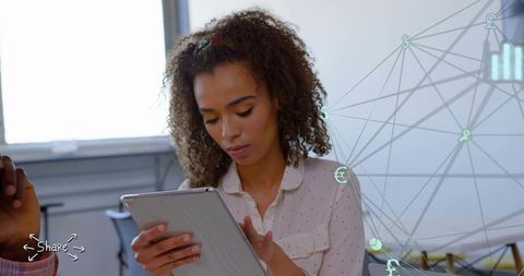 Young professional woman using tablet in coworking space with network overlay