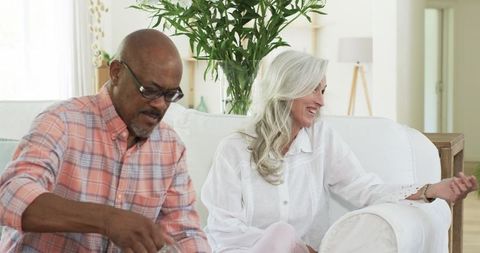 Senior Friends Sharing Drinks and Laughter on Comfortable Sofa
