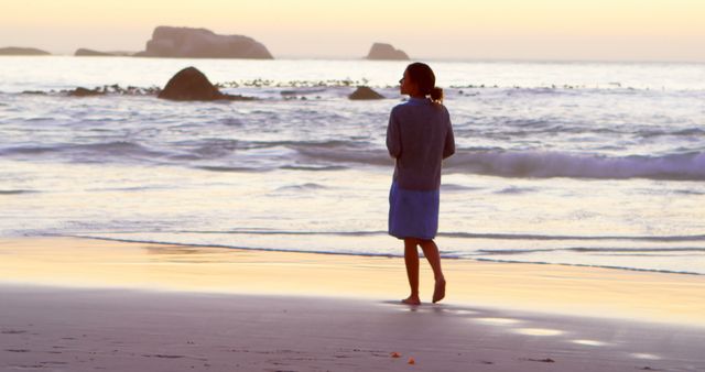 Woman Reflecting While Strolling on Tranquil Beach at Sunset - Download Free Stock Images Pikwizard.com