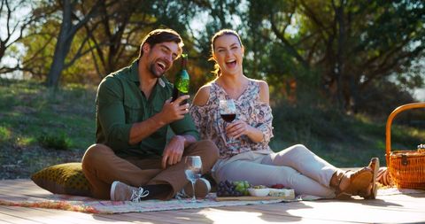 Happy Couple Enjoying Outdoor Wine Picnic Under Sunlit Trees - Download Free Stock Images Pikwizard.com