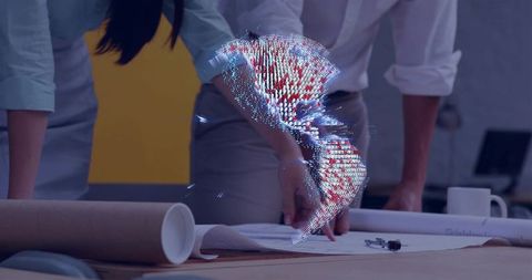 Engineers reviewing plans with holographic point cloud projection over blueprint table