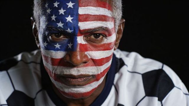 Senior man wearing full-face american flag paint and soccer jersey, patriotic portrait