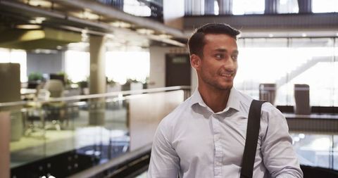 Smiling Professional Walking in Modern Office Atrium