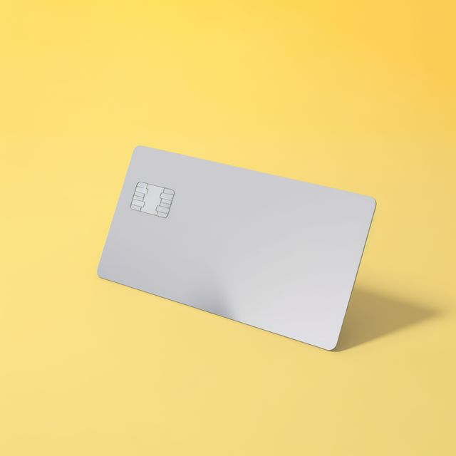 Blank grey credit card with microchip on yellow, copy space, created using generative ai technology. Emv chip, banking, spending, technology and finance mock up concept digitally generated image.