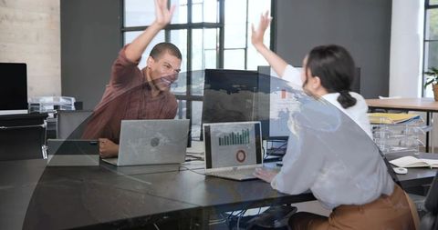 Team Celebrating Project Win with High Five Over Laptops Data Dashboard Analytics