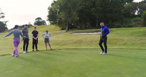 Friends Enjoying Golf Activity Together on Putting Green