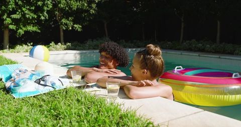 Cheerful Diverse Couple Relaxing by Backyard Poolside
