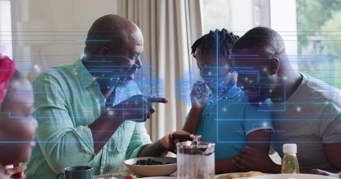Black multigenerational family exploring augmented reality on smartphone during breakfast