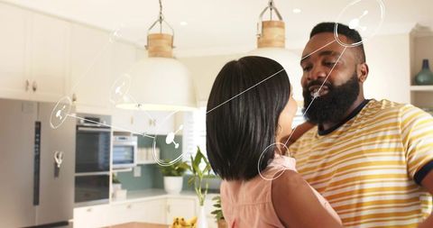 Couple embracing in modern kitchen with digital connection overlay for lifestyle marketing