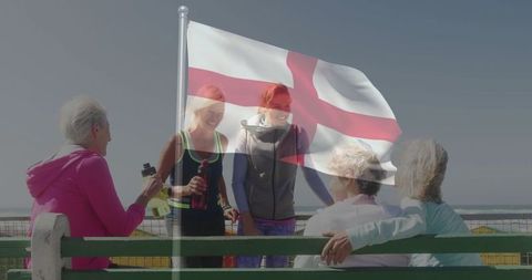 Women enjoying holiday with red cross flag fluttering