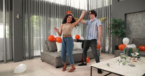 Happy Couple Dancing Celebrating in Living Room at Birthday Party