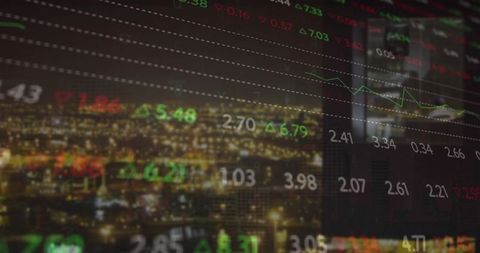 Nighttime city skyline showing live stock market tickers, green red arrows and line charts