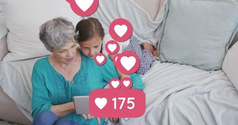 Grandmother and Granddaughter Enjoying Tablet Time with Social Media Hearts