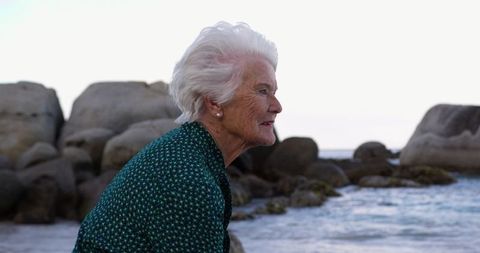 Thoughtful Senior Woman Reflecting by the Ocean