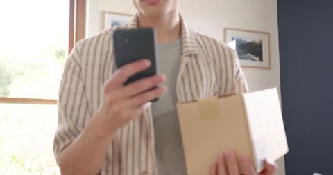 Man Checking Smartphone Holding Cardboard Delivery Package - Download Free Stock Images Pikwizard.com