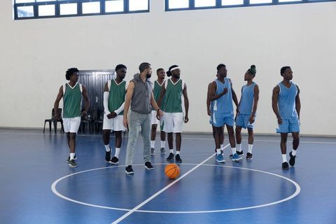 Diverse Basketball Team with Coach Practicing Inside Gym