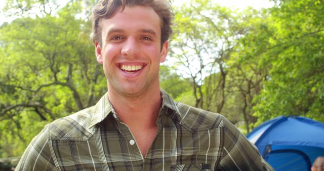 Smiling Man in Plaid Shirt at Outdoor Camping Site - Download Free Stock Images Pikwizard.com