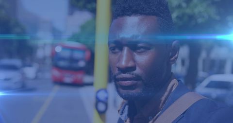 African american man waiting at urban bus stop in city