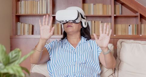 Woman Engaging in Virtual Reality Experience in Cozy Living Room
