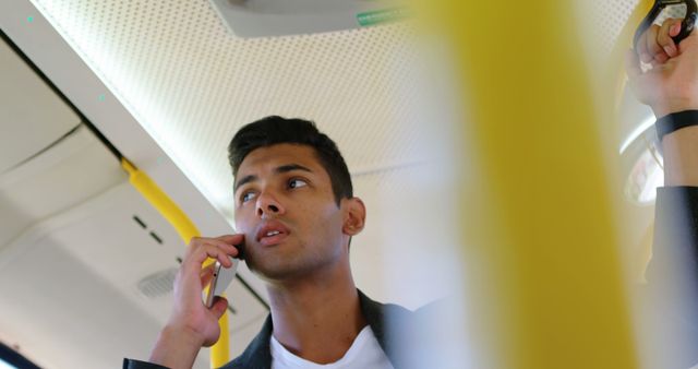 Young Man Talking on Phone in Public Transport - Download Free Stock Images Pikwizard.com