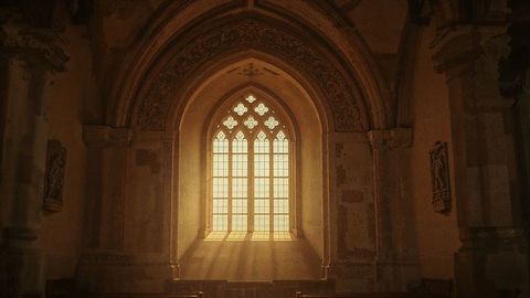 Sunlit church sanctuary with gothic tracery