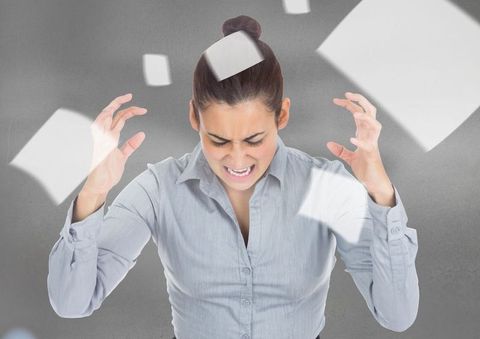 Frustrated professional surrounded by floating papers