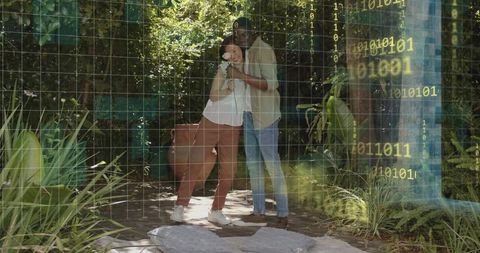 Couple embracing on backyard patio holding white flower with binary code overlay
