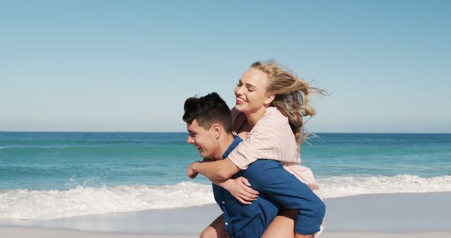 Happy Couple Enjoying Piggyback Ride on Beach on Sunny Day - Download Free Stock Images Pikwizard.com