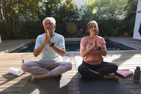 Senior Couple Meditating by Backyard Plunge Pool for Tranquility