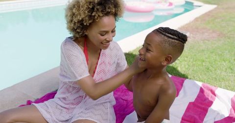 Joyful Mother and Son Relaxing by Backyard Pool