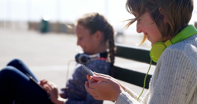 Teen Girls Enjoying Digital Devices and Headphones Outdoors - Download Free Stock Images Pikwizard.com