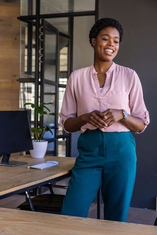 Confident professional smiling at modern office desk