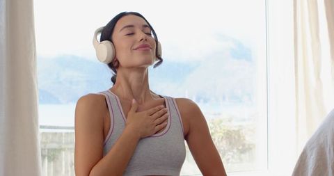 Woman practicing mindfulness in tranquil bedroom setting