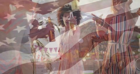 Friends toasting with beer at tropical beach summer party under american flag overlay