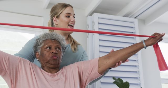 Elderly Woman Using Resistance Band with Assistance - Download Free Stock Images Pikwizard.com