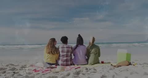 Four Women Relaxing on Beach Blanket After Arrival