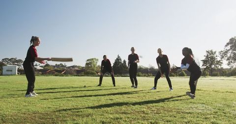 Female Cricket Team Practicing Outdoors in Intense Game Play