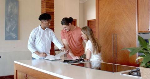 Consulting in modern kitchen with diverse group discussing plans