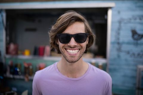 Smiling Young Man at Food Truck Wearing Sunglasses and Purple T-Shirt