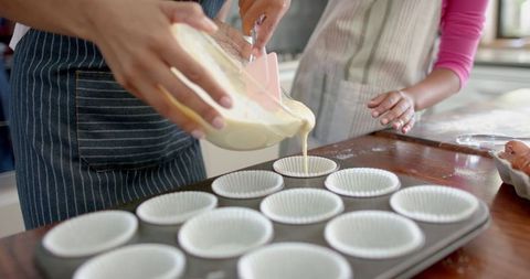 Mother and Daughter Baking Muffins Together in Kitchen