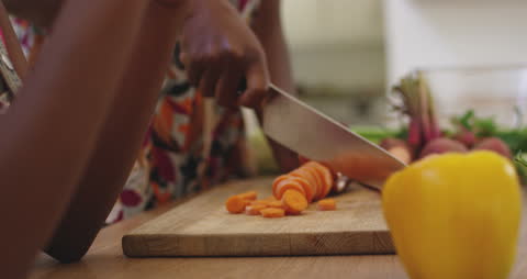 Close-up of Mother and Daughter Chopping Fresh Vegetables